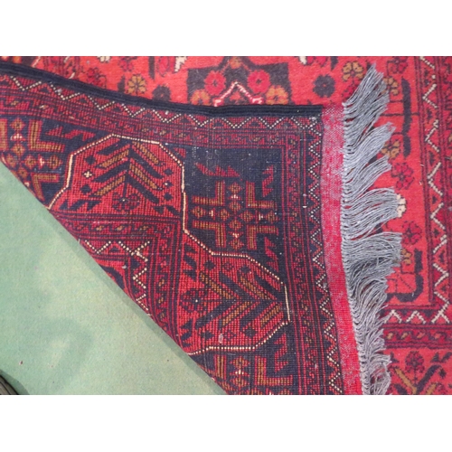 4184 - An Eastern red ground wool runner rug with geometric design, tasselled ends, 200cm x 83cm