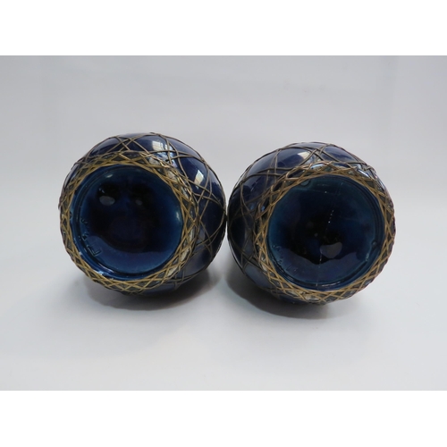 4391 - A pair of Japanese vases in cobalt blue encased with a wirework design, 20cm high, one a/f,