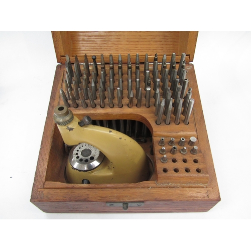 6050 - A cased staking tool with various punches, together with another stake with assorted punches, a sele... 