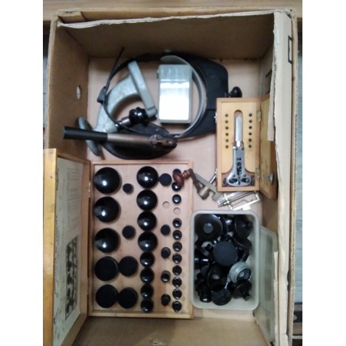 6053 - A box of mixed tools and equipment including mainspring winders, case openers, head visor and lenses... 