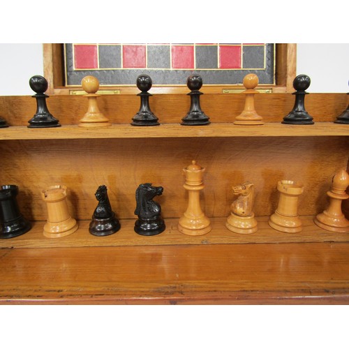 9056 - An early 20th Century oak cased games compendium with boxwood and ebony chess pieces (king 2.5” high... 