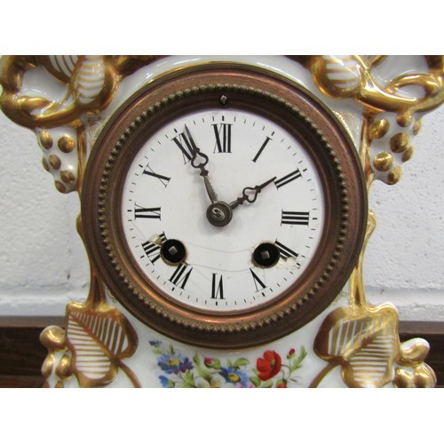 1259 - A Continental style clock garniture with gilt and flower design, mounted by a seated gentleman (a/f)... 