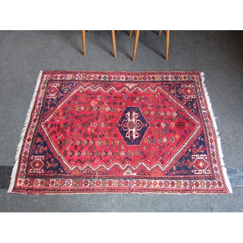 1016 - An Eastern red ground geometric design wool rug with tasselled ends, 170cm x 127cm     (R) £25