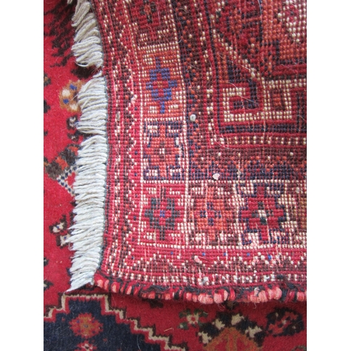 1016 - An Eastern red ground geometric design wool rug with tasselled ends, 170cm x 127cm     (R) £25