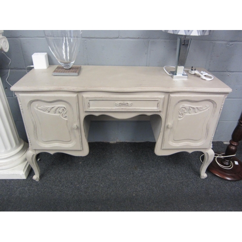 1036 - A French grey painted dressing table with foliate carved doors and scroll feet, 74cm high x 130cm wi... 