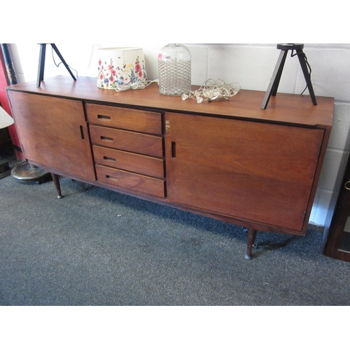 1063 - A retro teak sideboard, central bank of four drawers flanked by two cupboards, veneer damaged to doo... 