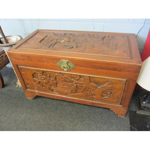 1067 - A 20th Century camphor wood coffer/blanket box with carved figural landscape panels, 58cm high x 104... 