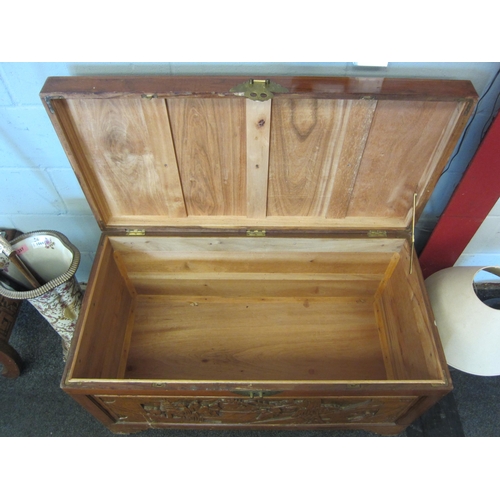 1067 - A 20th Century camphor wood coffer/blanket box with carved figural landscape panels, 58cm high x 104... 