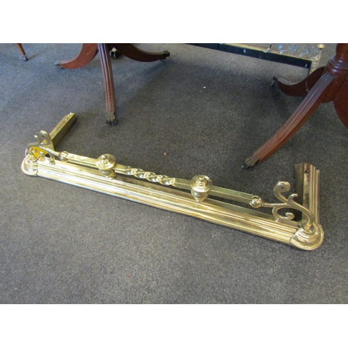 1110 - A brass fire fender with scroll and rope twist detail, 130cm long