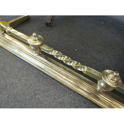 1110 - A brass fire fender with scroll and rope twist detail, 130cm long