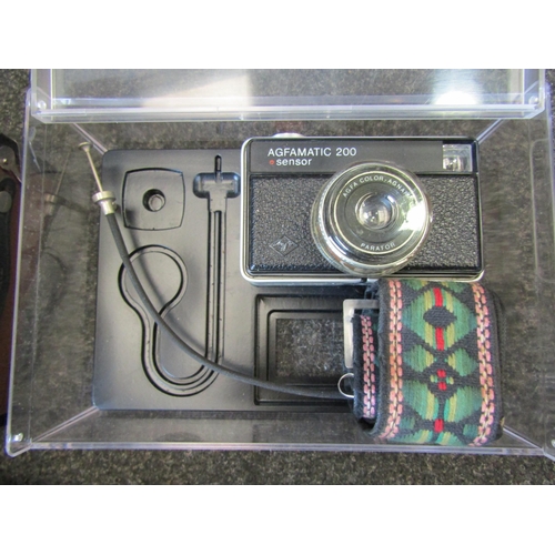 1149 - A box containing a quantity of cameras including lens, cased Zenit-E camera