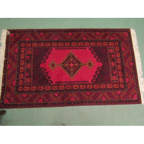 4003 - A Khuristan Axminster red ground wool rug, single medallion, multiple geometric borders, tasselled e... 