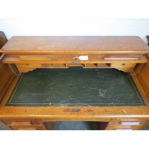 1040 - An early 20th Century oak rolltop desk with green leather insert (worn), eight drawers and two brush... 