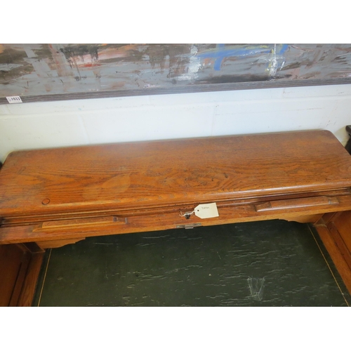 1040 - An early 20th Century oak rolltop desk with green leather insert (worn), eight drawers and two brush... 