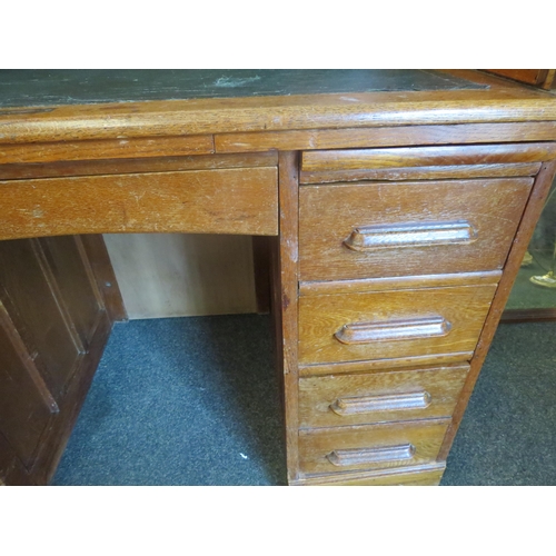 1040 - An early 20th Century oak rolltop desk with green leather insert (worn), eight drawers and two brush... 