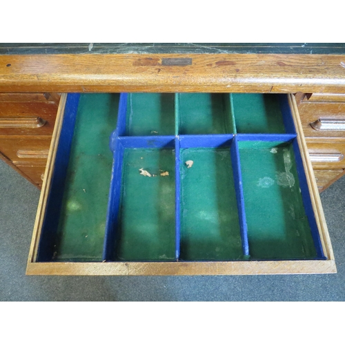 1040 - An early 20th Century oak rolltop desk with green leather insert (worn), eight drawers and two brush... 