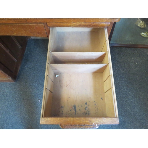 1040 - An early 20th Century oak rolltop desk with green leather insert (worn), eight drawers and two brush... 