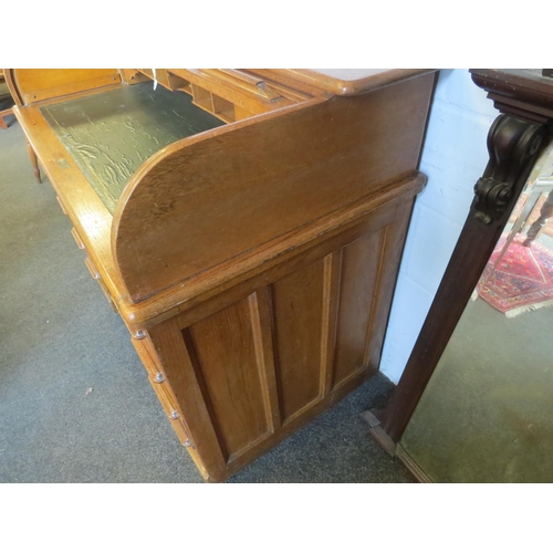 1040 - An early 20th Century oak rolltop desk with green leather insert (worn), eight drawers and two brush... 