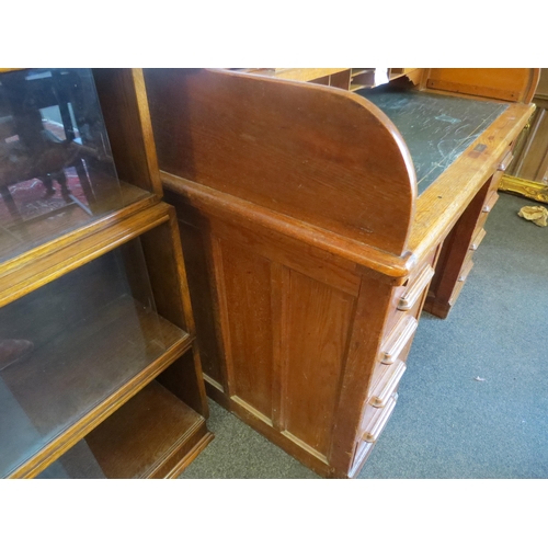1040 - An early 20th Century oak rolltop desk with green leather insert (worn), eight drawers and two brush... 