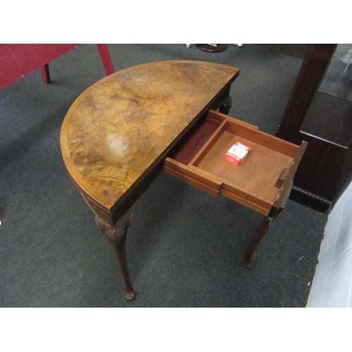 1055 - An early 20th Century mahogany demi-lune walnut card table with baize surface to interior on pad fee... 