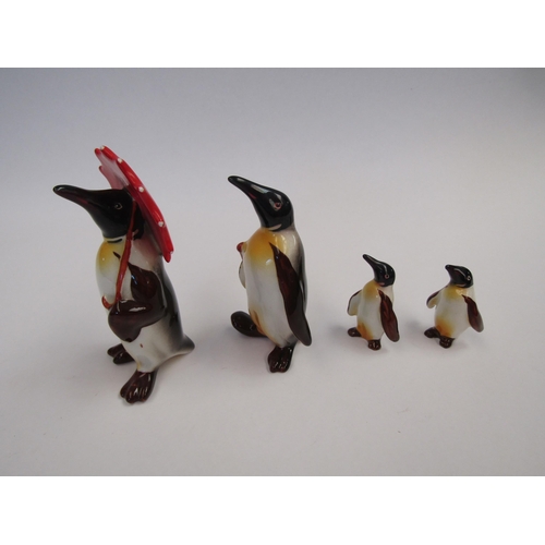 9048 - A set of four Beswick Family Penguins. Penguin with umbrella model no. 802. Penguin with walking sti... 