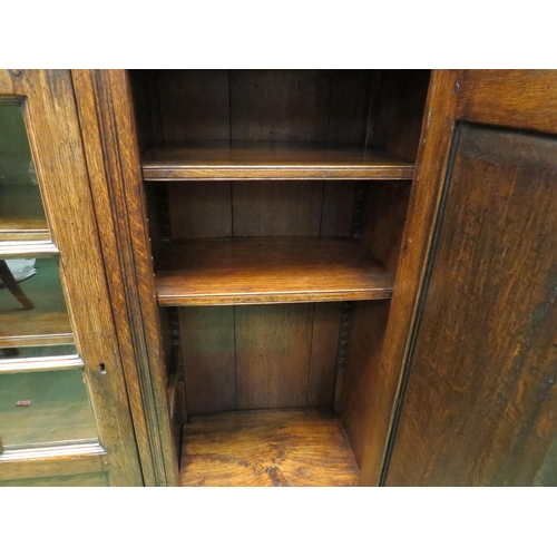 4057 - In the manner of Titchmarsh & Goodwin a carved oak three door bookcase (two panel glazed) with two k... 