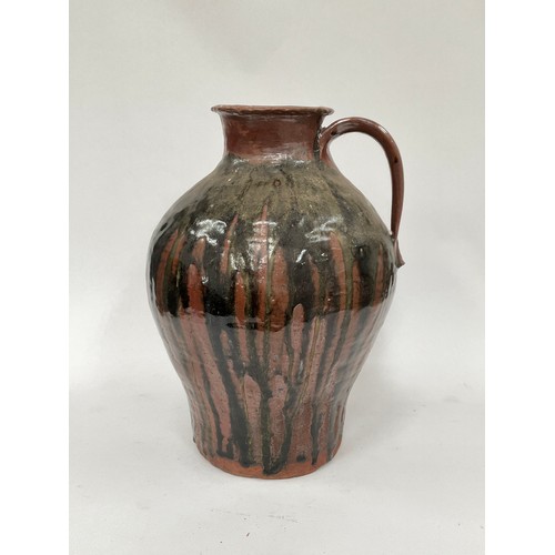 4064 - A large pottery vessel with single handle, drip glaze to body, 39cm tall