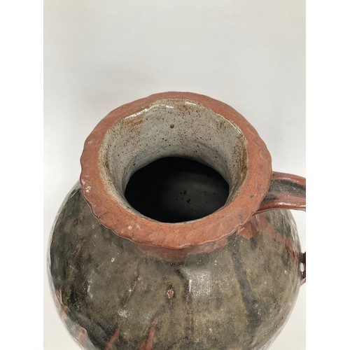 4064 - A large pottery vessel with single handle, drip glaze to body, 39cm tall