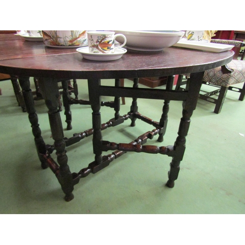 4085 - An 18th Century pegged oak country cottage oval top gateleg dining table the rising leaves over turn... 