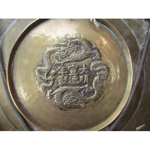 4096 - A pair of Japanese brass chargers with character marks to base, 26cm diameter