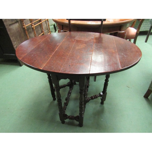 4105 - An 18th Century country oak gate leg table of small proportions the oval top rising leaves on turned... 