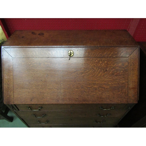 4136 - A George III country oak bureau with fitted interior over four graduating long drawers on bracket fe... 