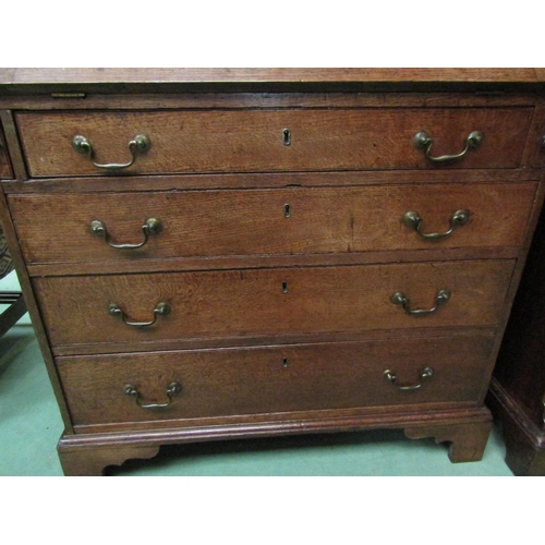 4136 - A George III country oak bureau with fitted interior over four graduating long drawers on bracket fe... 