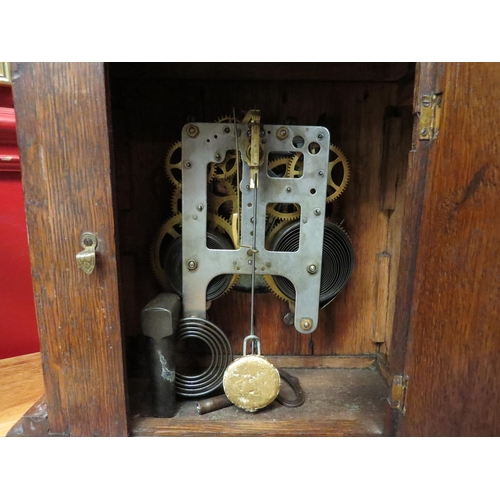 4160 - An early 20th Century American oak cased mantel clock of architectural form, with key and pendulum