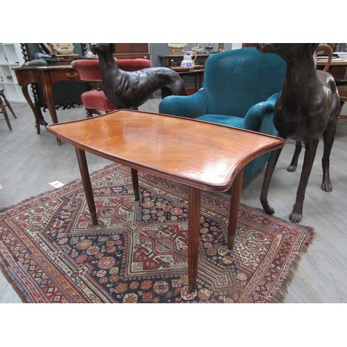 4230 - LAZZLO HOENIG - A shaped walnut top coffee table with reeded legs to brass cup feet, 54cm high x 94c... 