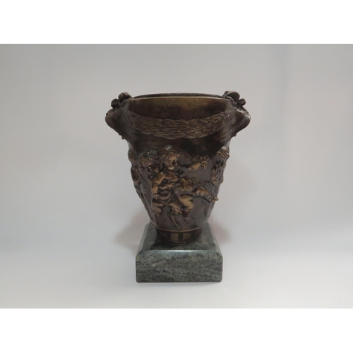 4294 - A cast bronzed urn decorated with putti and classical symbolism with mythical lion handles on polish... 