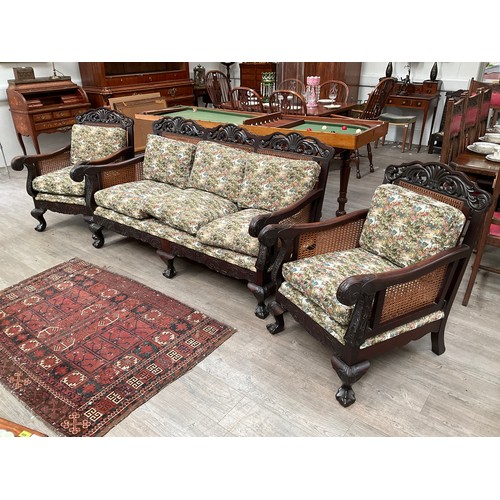 4132 - A mahogany carved frame three piece bergere suite with duck down filled cushions, carved scroll arms... 