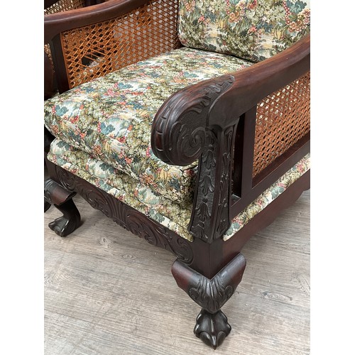 4132 - A mahogany carved frame three piece bergere suite with duck down filled cushions, carved scroll arms... 