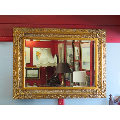 4025 - A large gilt framed rectangular bevel edged wall mirror, decorative frame, 87cm x 117cm total