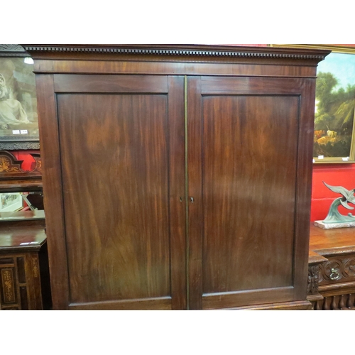 4142 - A George III flame mahogany linen press with dentil cornice over two doors (with key), opening to re... 