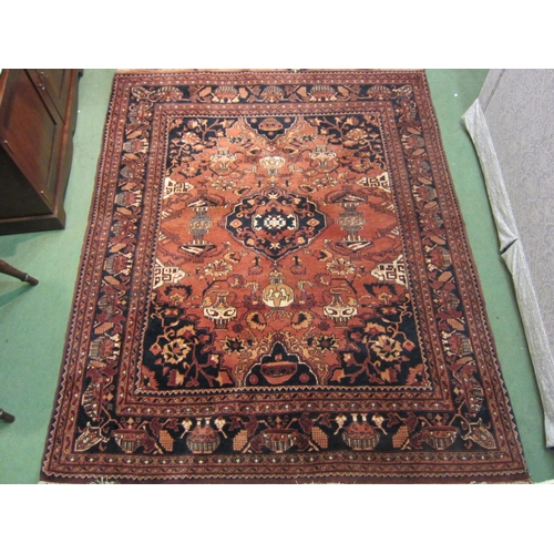 4487 - A large terracotta and blue ground hand woven wool rug with central lozenge and multiple borders, 19... 