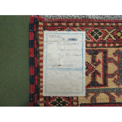 4023 - A red ground wool rug with multiple borders, 182cm x 113cm