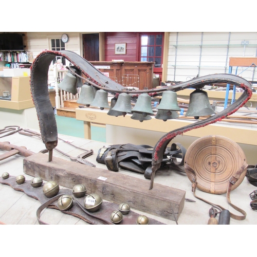 9185 - A set of heavy horse bells, 12 bells mounted on iron and leather frame on wooden base       (C)