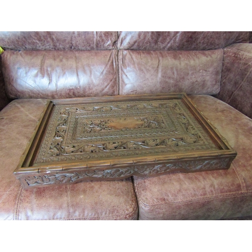 1035 - An Indian heavily carved hardwood tray with floral detailing, 56cm long x 36cm wide