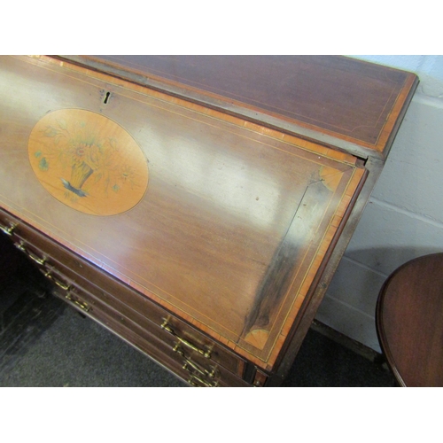 1077 - A 19th Century mahogany bureau, the front with oval marquetry panel, over four drawers, satinwood cr... 