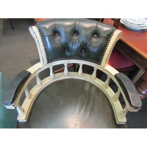 1138 - An early 20th Century captain's chair with leather seat and back, stud detail a/f one castor loose i... 