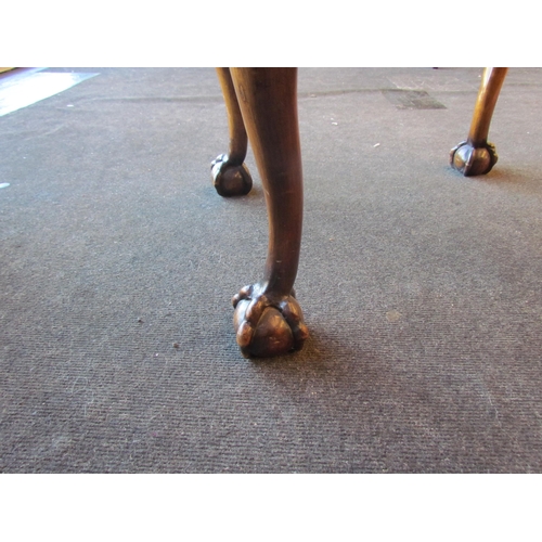 1017 - A walnut stool with ball in claw feet and tapestry upholstered seat pad