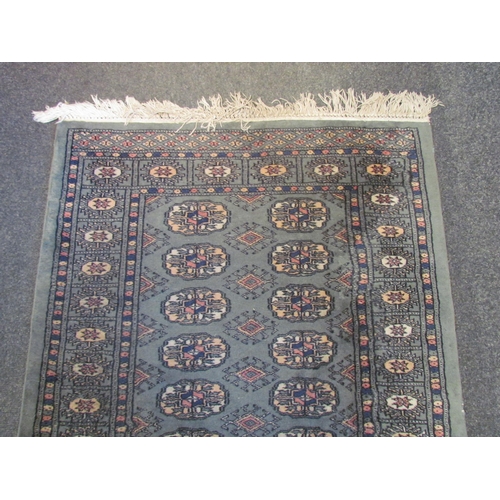 1025 - A geometric runner rug, green ground, tasselled ends, 247cm x 81cm