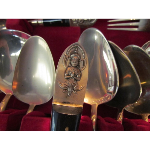 1094 - A canteen of brass cutlery, finials embossed with Indian figures