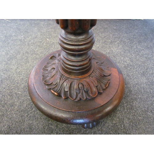 1103 - A 19th Century mahogany circular top lamp table on a turned and fluted column with carved leaf circu... 